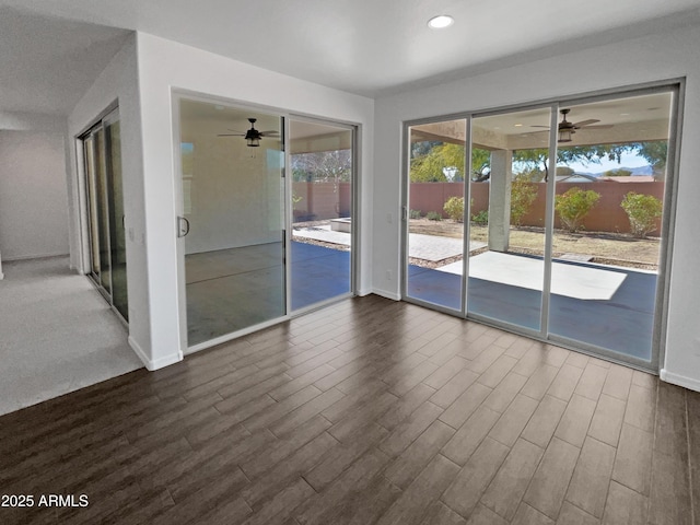 empty room with ceiling fan and dark hardwood / wood-style flooring