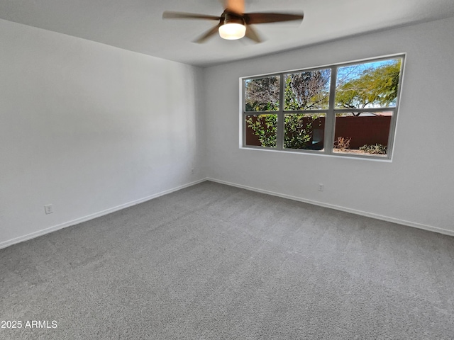 carpeted spare room featuring ceiling fan