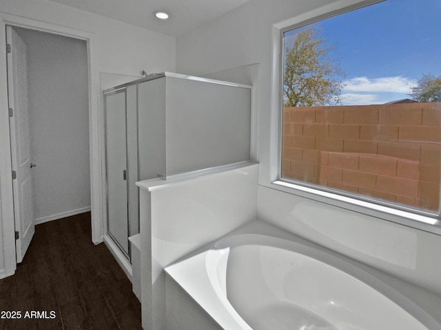 bathroom featuring plus walk in shower and hardwood / wood-style floors