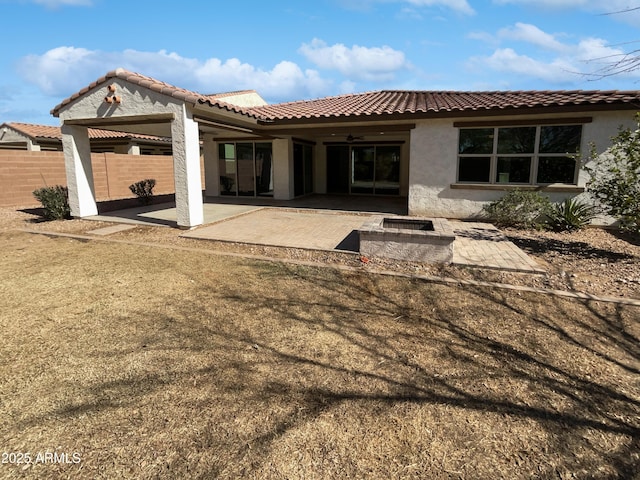 rear view of property with ceiling fan and a patio area