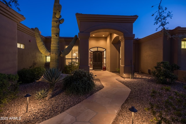 entrance to property featuring stucco siding