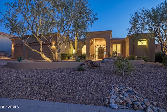 view of front of house featuring a garage, driveway, and stucco siding