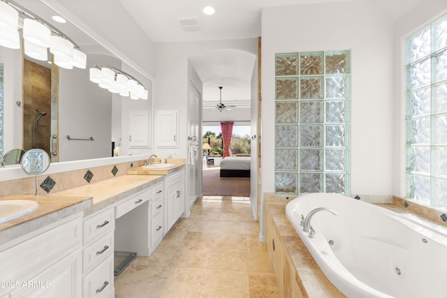 full bathroom featuring a ceiling fan, a tub with jets, visible vents, double vanity, and a sink