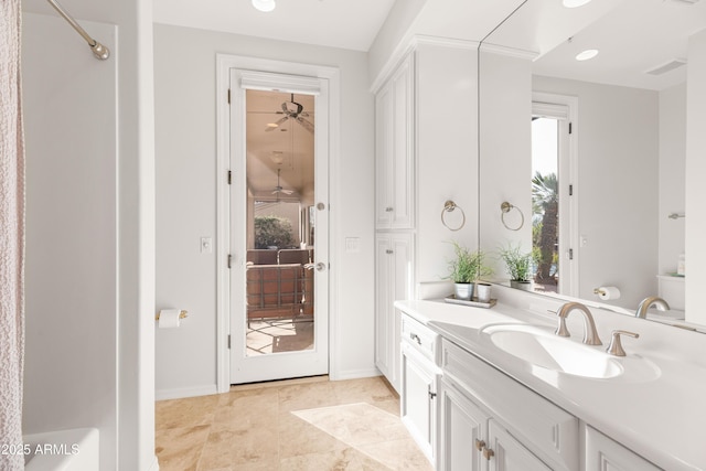 full bathroom with vanity, ceiling fan, baseboards, and walk in shower