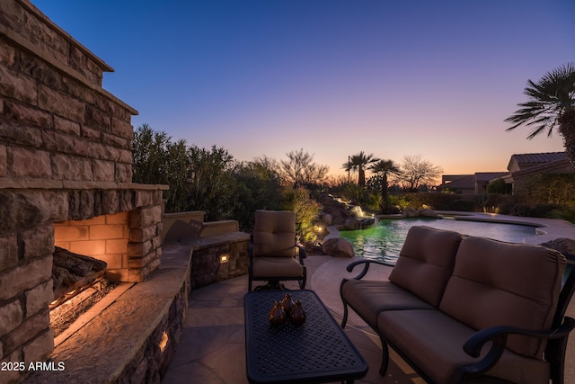 patio terrace at dusk featuring an outdoor pool and outdoor lounge area