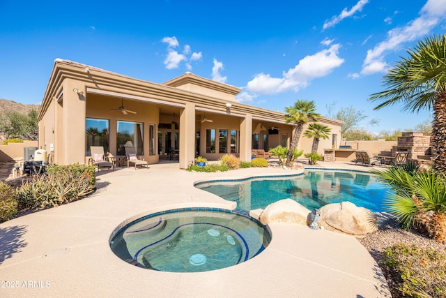 view of swimming pool featuring fence, a pool with connected hot tub, ceiling fan, a patio area, and outdoor dry bar