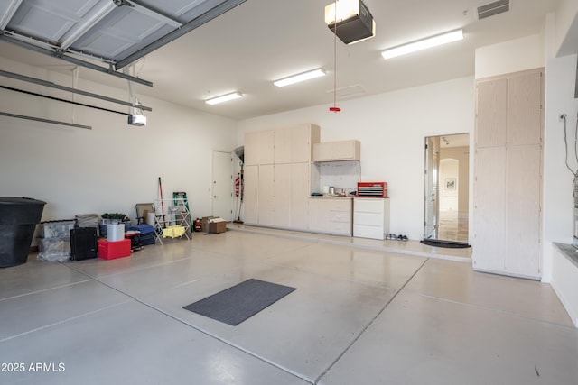 garage with visible vents and a garage door opener