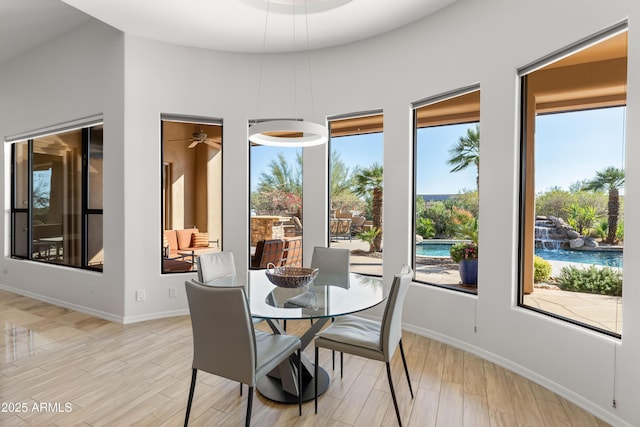 dining space with light wood-style flooring and baseboards