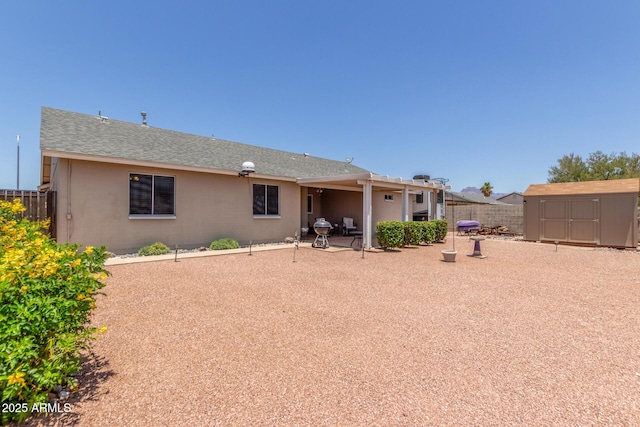 1925 W 12th Ave, Apache Junction, AZ 85120 - back of property featuring a storage shed, stucco siding, a patio, and roof with shingles