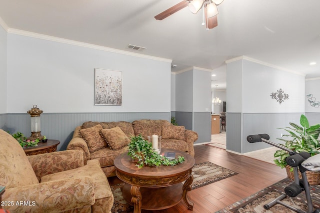 1925 W 12th Ave, Apache Junction, AZ 85120 - living room featuring a wainscoted wall, ornamental molding, a ceiling fan, wood finished floors, and a chandelier