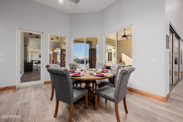 dining room with baseboards, light wood-style floors, and a ceiling fan