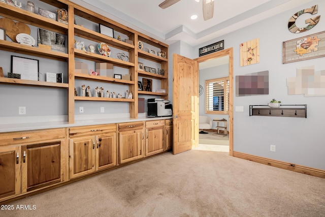 kitchen featuring baseboards, ceiling fan, light countertops, light carpet, and open shelves