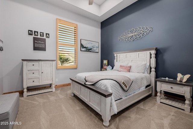 bedroom featuring light colored carpet, baseboards, and ceiling fan