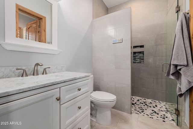 full bath featuring vanity, a shower stall, toilet, and tile patterned flooring