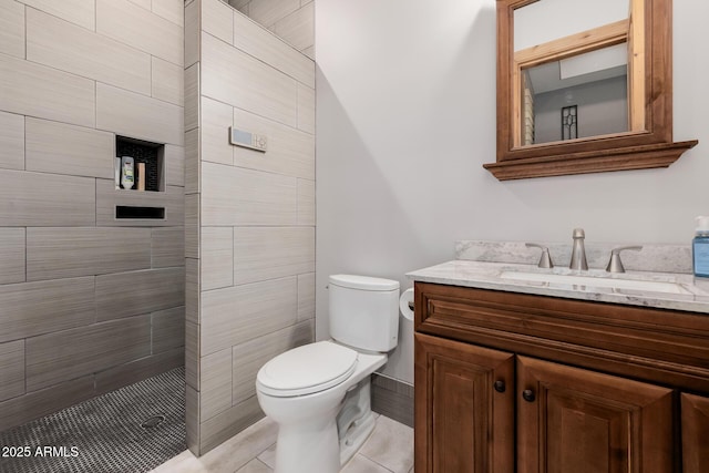 full bath featuring a tile shower, toilet, and vanity