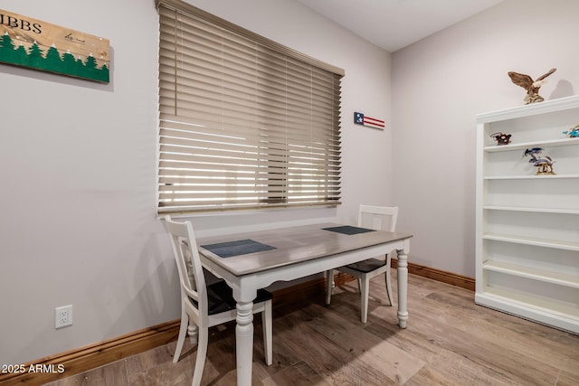 dining room with baseboards and light wood finished floors