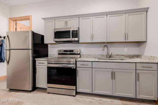 kitchen with a sink, appliances with stainless steel finishes, and gray cabinets