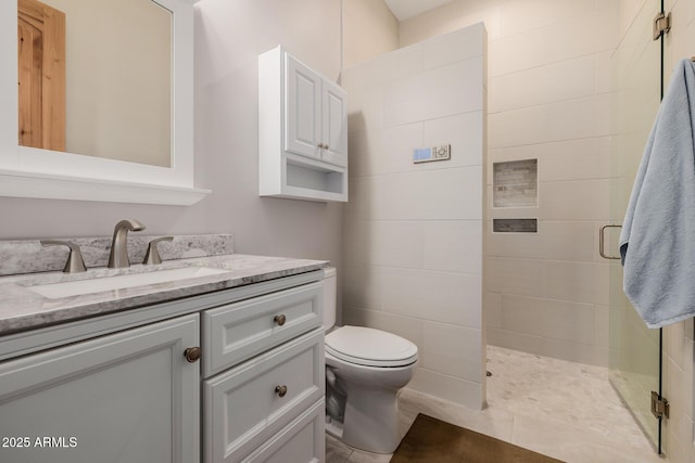 full bathroom featuring a shower stall, vanity, and toilet