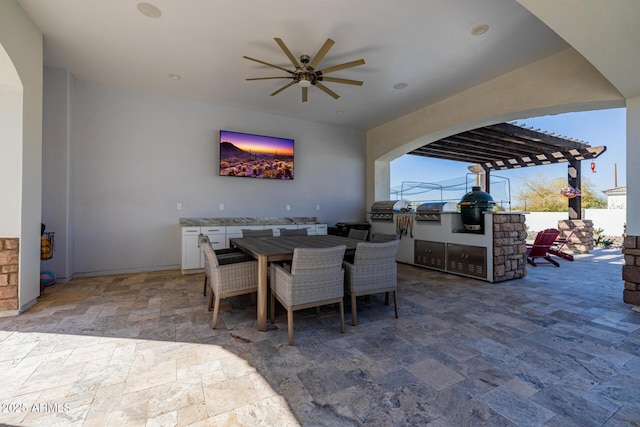 view of patio / terrace featuring outdoor dining space, an outdoor kitchen, and a ceiling fan