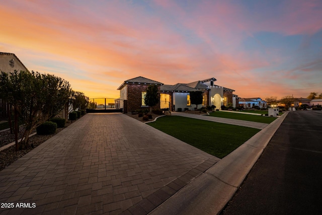 view of front of home with decorative driveway and a front yard