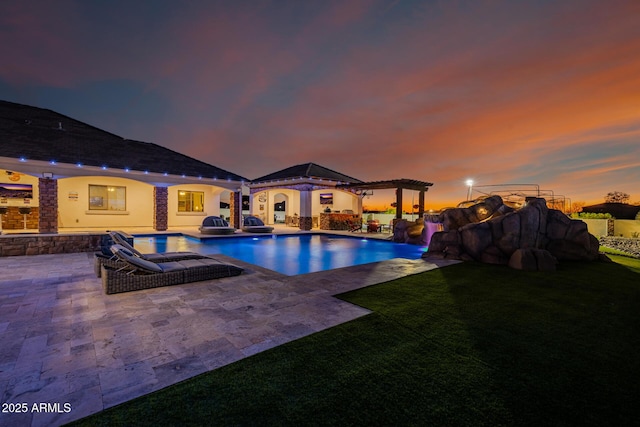 pool featuring a pergola, a patio area, and a lawn