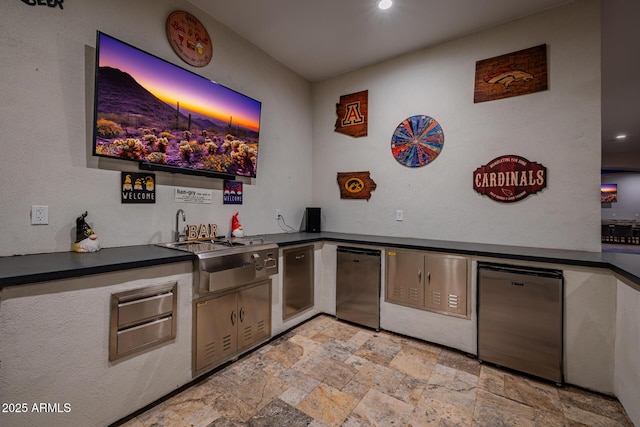 bar featuring indoor wet bar, refrigerator, a warming drawer, and stone finish floor