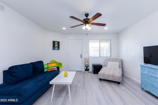 living room featuring ceiling fan and light hardwood / wood-style flooring