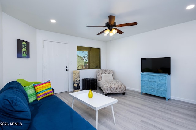 living room with light wood-type flooring and ceiling fan