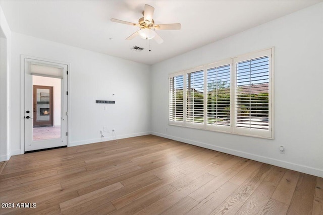 empty room with ceiling fan and light hardwood / wood-style floors