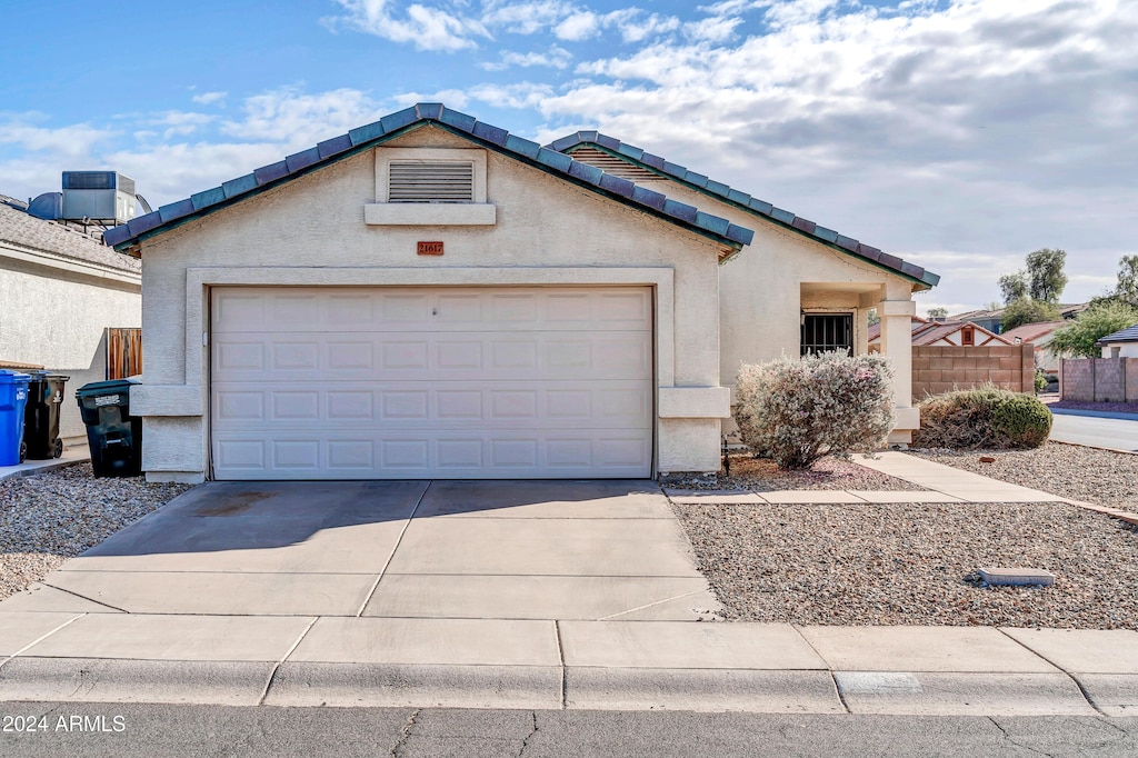 ranch-style home with central AC and a garage