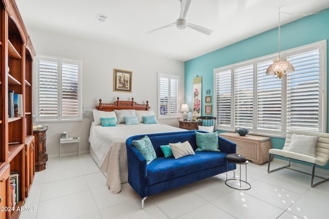 bedroom featuring tile patterned floors and ceiling fan with notable chandelier