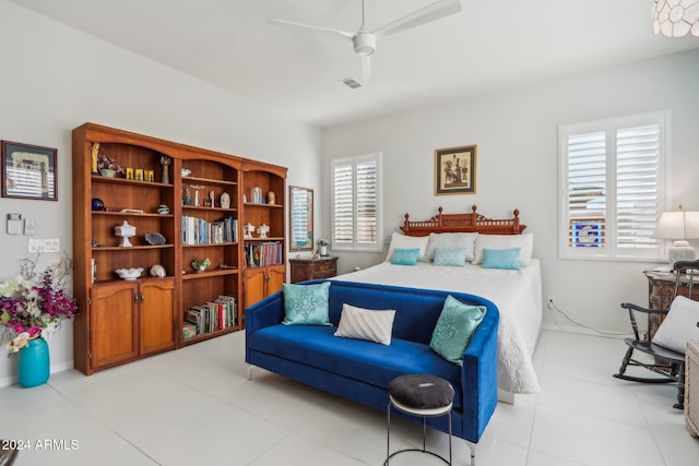 tiled bedroom with multiple windows and ceiling fan