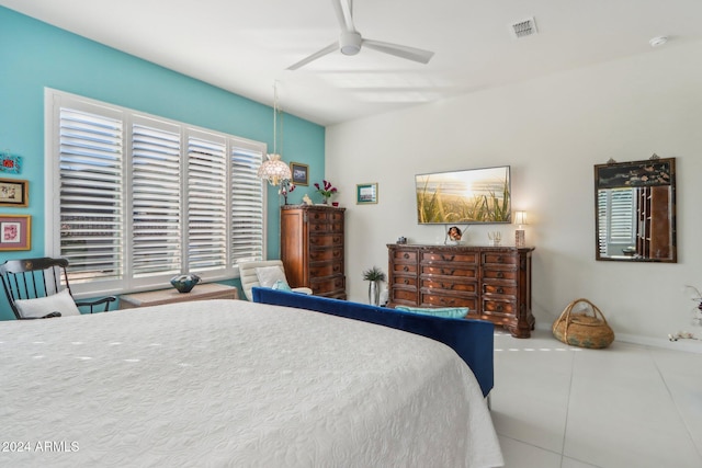 bedroom with ceiling fan with notable chandelier and tile patterned floors