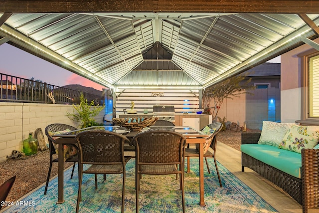 patio terrace at dusk featuring an outdoor hangout area and grilling area