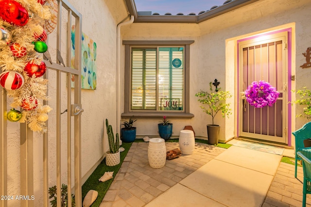 exterior entry at dusk featuring a patio