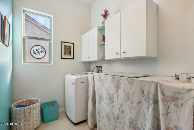 clothes washing area featuring cabinets, hookup for a washing machine, and light tile patterned floors