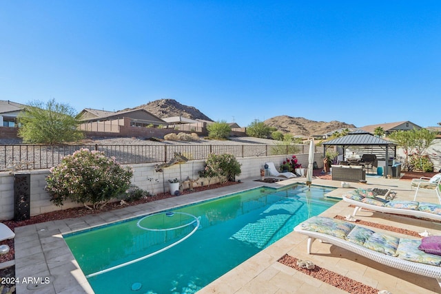 view of swimming pool with a gazebo, a mountain view, a patio, and an outdoor hangout area