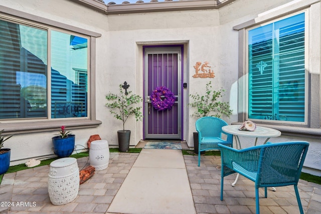 view of exterior entry with a patio