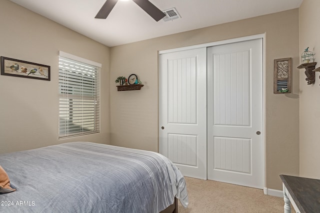 bedroom featuring ceiling fan, light colored carpet, and a closet