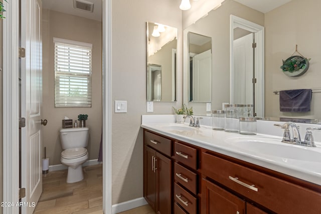 bathroom with hardwood / wood-style floors, vanity, and toilet