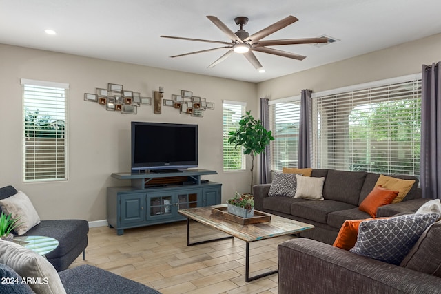 living room featuring ceiling fan, light wood-type flooring, and a healthy amount of sunlight