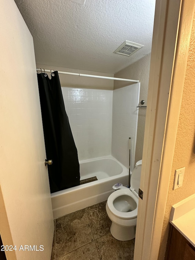 bathroom featuring shower / tub combo with curtain, a textured ceiling, and toilet