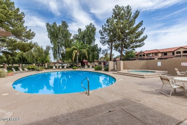 view of swimming pool with a patio area and a community hot tub