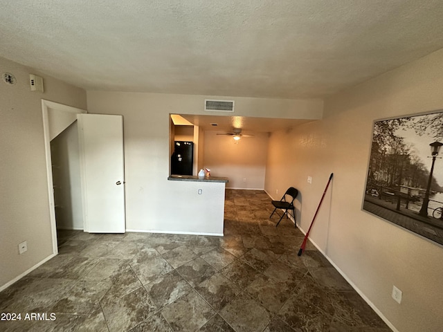 unfurnished room featuring ceiling fan and a textured ceiling