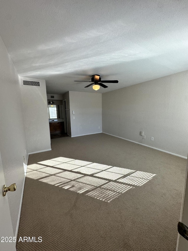 unfurnished living room with dark colored carpet and ceiling fan