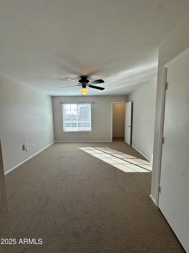 carpeted empty room featuring ceiling fan and a textured ceiling