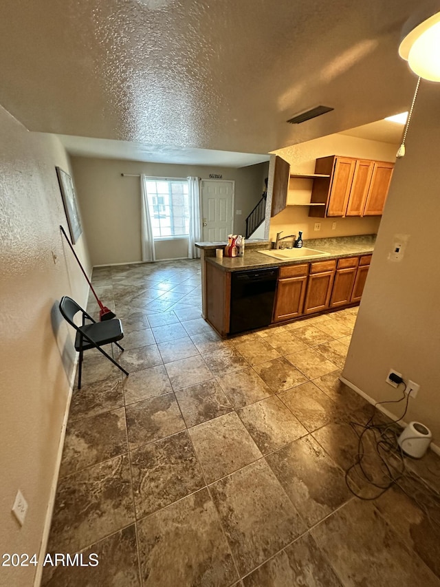 kitchen featuring a textured ceiling, black dishwasher, and sink