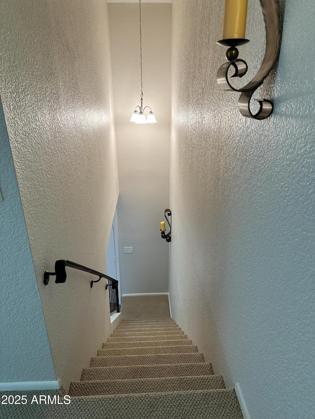 staircase with an inviting chandelier