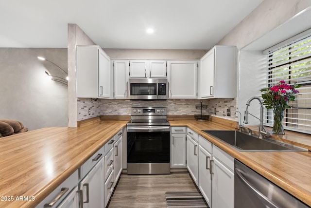 4901 E Kelton Ln Unit 1052, Scottsdale, AZ 85254 - kitchen with appliances with stainless steel finishes, a sink, backsplash, and light wood-type flooring