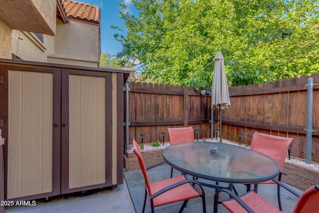 4901 E Kelton Ln Unit 1052, Scottsdale, AZ 85254 - view of patio with a shed, a fenced backyard, an outdoor structure, and outdoor dining space